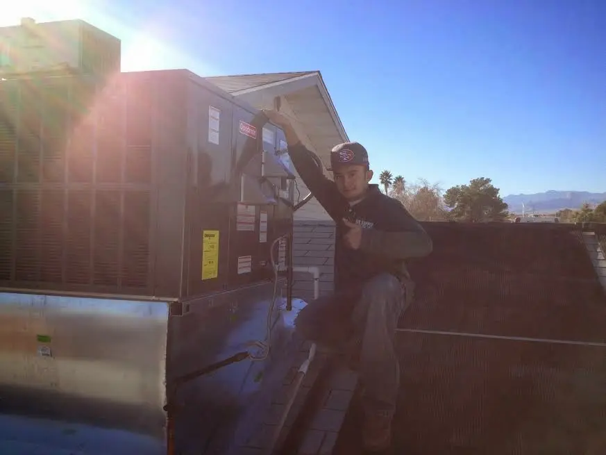 HVAC technician performing Boiler Repair on a rooftop unit in Lowell